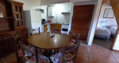 a kitchen with a wooden table and a kitchen with a bed at Cabañas Del Lacar in San Martín de los Andes