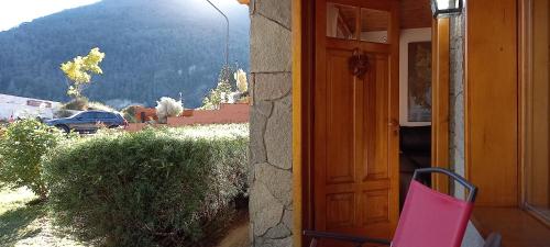 a pink chair sitting in front of a door at Cabañas Del Lacar in San Martín de los Andes