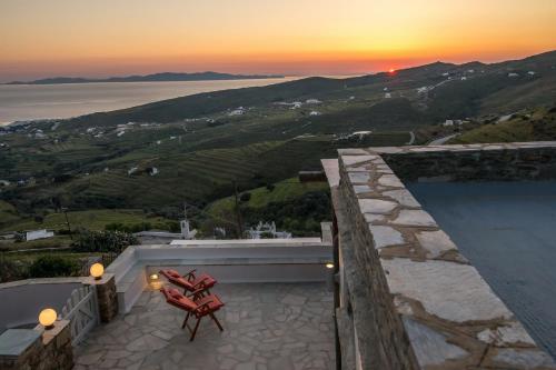 a view of a sunset from a house with a red chair at Villa Adele in Arnados