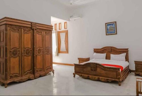 um quarto com uma cama e um grande armário de madeira em RedDoorz at Daffi Araya em Malang