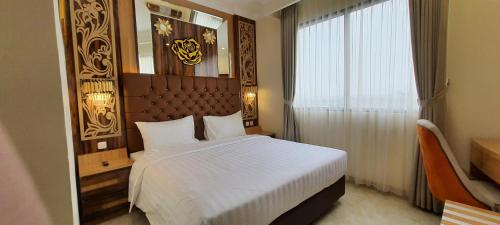 En eller flere senge i et værelse på Hotel Daily Inn Bandung