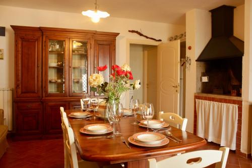 una mesa de comedor con un jarrón de flores. en Villa Chiara en Santo Stefano al Mare