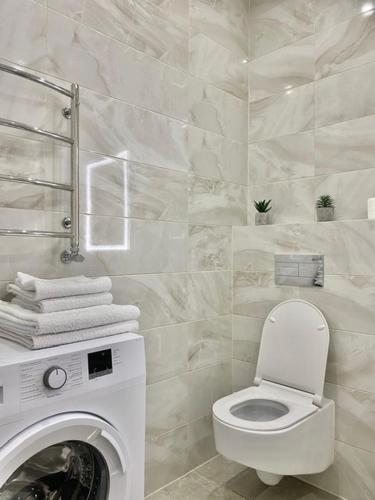 a bathroom with a toilet and a washing machine at ВІП апартаменти район автовокзалу ЖК Арена,ЖК Great House in Rivne