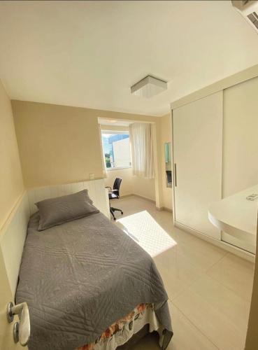1 dormitorio con 1 cama y baño con lavamanos en Apto Vista Mar- Jardim Camburi - Vitória ES, en Vitória