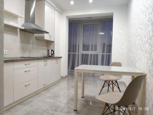 a kitchen with a table and chairs in a room at ВІП апартаменти район автовокзалу ЖК Арена,ЖК Great House in Rivne