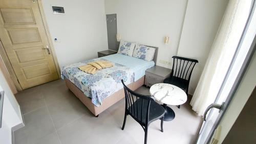 a small bedroom with a bed and a table and chairs at Ressa Apart in Marmaris