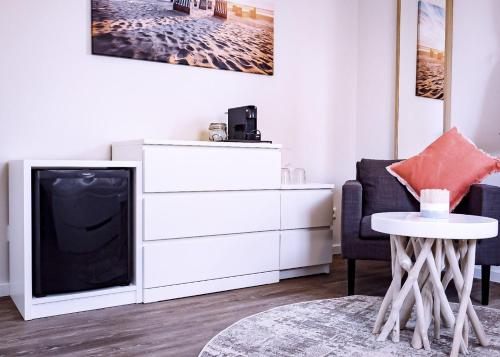 un soggiorno con TV e cassettiera bianca di Flippi-s-Hues-NORD a Westerland