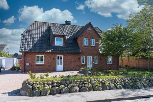 una casa de ladrillo rojo con techo negro en Flippi-s-Hues-NORD en Westerland