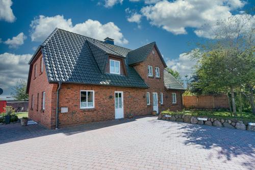 una casa de ladrillo rojo con techo negro en Flippi-s-Hues-NORD en Westerland