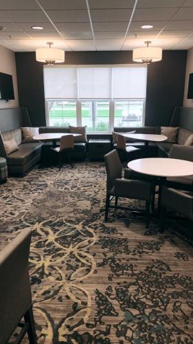 a waiting room with tables and couches and chairs at Sonesta ES Suites Parsippany Morris Plains in Parsippany