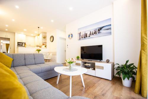 a living room with a couch and a tv and a table at Milara Apartments in Budva