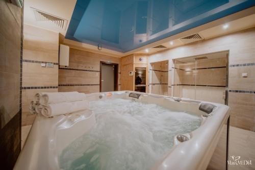 y baño con bañera grande llena de agua. en Karpacki & SPA adults only en Karpacz