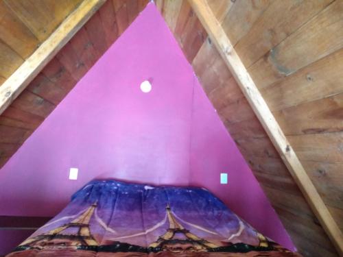 a purple room with a bed in a attic at GoEs Loft in Comitán de Domínguez