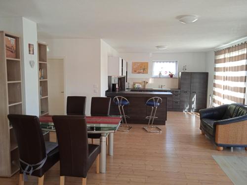 a living room with a table and chairs and a kitchen at Ferienwohnung Kleb in Malterdingen
