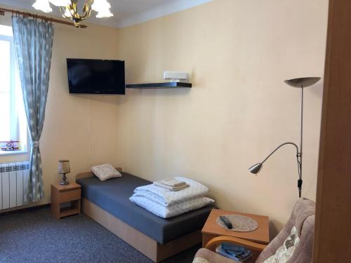 a small room with a bed with a tv on the wall at Mieszkanie na Starym Mieście in Olsztyn