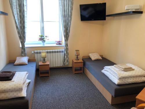 a room with two beds and a tv on the wall at Mieszkanie na Starym Mieście in Olsztyn