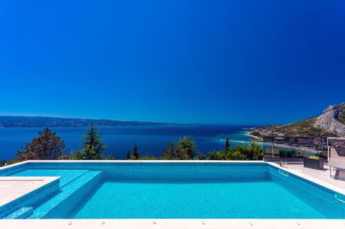 a swimming pool with a view of the water at Villa Belvedere with heated pool, billiards, Media room, sea views,10 pax in Omiš