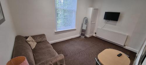 a living room with a couch and a table at No 7 - 1 BED NEAR SEFTON PARK AND LARK LANE in Liverpool