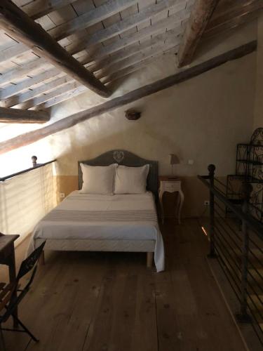 - une chambre avec un lit blanc et du parquet dans l'établissement Gîte de caractère 72m2, à Rochefort-du-Gard