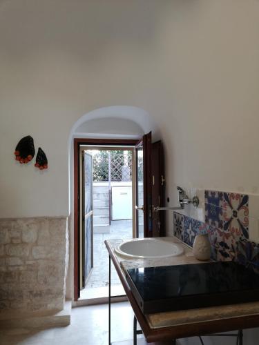 a bathroom with a sink and a tub in a room at Luxury Trulli sabotino 61 in Alberobello