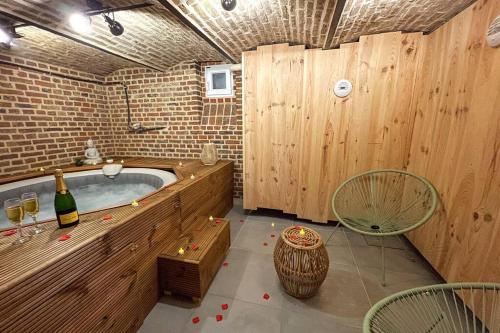 a bathroom with a tub with a bottle of wine at Studio Spa Privatif NETFLIX Unique Amiens in Amiens