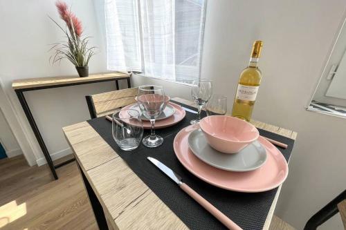 - une table avec un bol et une bouteille de vin dans l'établissement Studio NETFLIX Unique Amiens, à Amiens