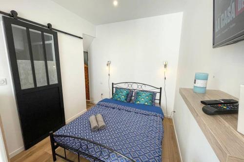 - une petite chambre avec un lit et une couette bleue dans l'établissement Studio Spa Privatif NETFLIX Unique Amiens, à Amiens