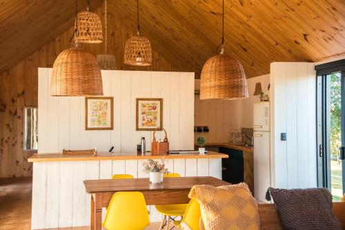 a kitchen with a table and chairs and pendant lights at Finca Granero in Potrero de Garay