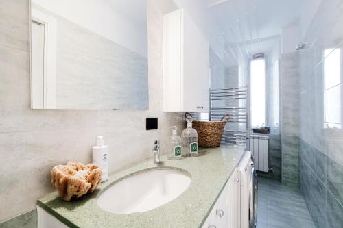 a white bathroom with a sink and a mirror at Promenade - My Home In Como in Cernobbio