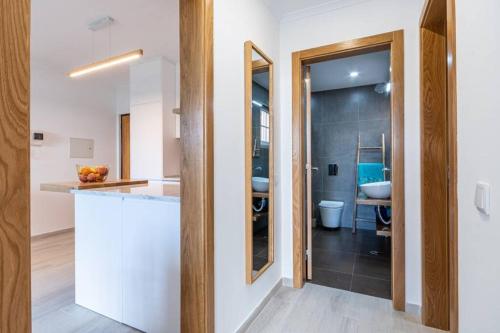 a bathroom with a sink and a toilet and a mirror at TRÓIA BOUTIQUE APARTMENT in Troia