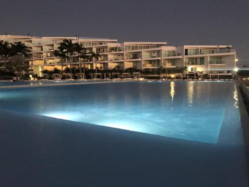 a large swimming pool in front of a building at night at Departamento privado a pie de playa en nuevo vallarta in Bucerías