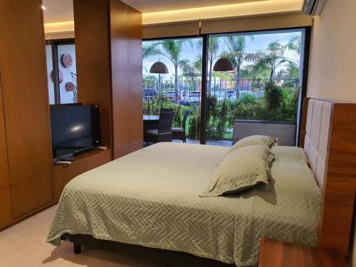 a bedroom with a bed and a tv and a window at Departamento privado a pie de playa en nuevo vallarta in Bucerías