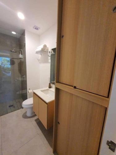 a bathroom with a toilet and a glass shower at Departamento privado a pie de playa en nuevo vallarta in Bucerías