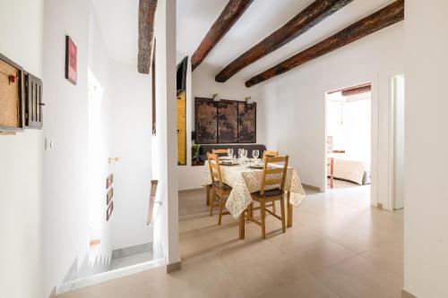 uma sala de jantar com paredes brancas e uma mesa e cadeiras em Residenza San Gregorio Armeno em Nápoles