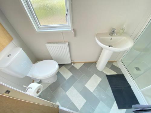 a bathroom with a toilet and a sink at Waggy Tails - Hot Tub - Pet Friendly in South Cerney