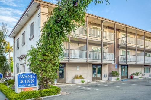 an apartment building with a sign in front of it at Avania Inn of Santa Barbara in Santa Barbara
