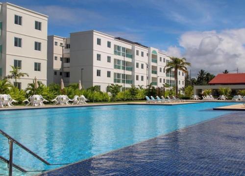 een groot zwembad voor een gebouw bij Palm Village Acqua in Porto De Galinhas