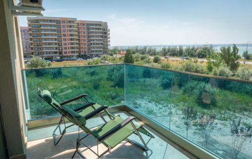 uma cadeira numa varanda com vista para um edifício em North Club Apartments II em Mamaia