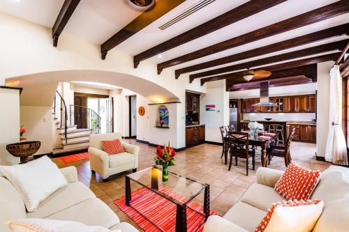 a living room with white furniture and a dining room at Dream House in prestigious Hacienda Pinilla in Tamarindo