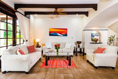 a living room with two white couches and a table at Dream House in prestigious Hacienda Pinilla in Tamarindo