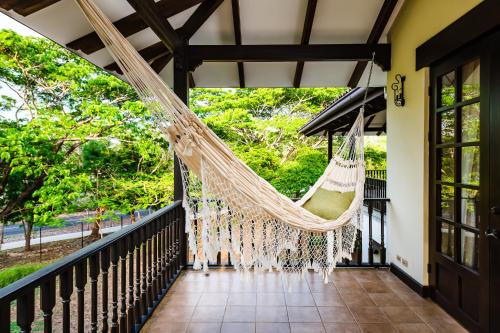 a hammock on the porch of a house at Dream House in prestigious Hacienda Pinilla in Tamarindo