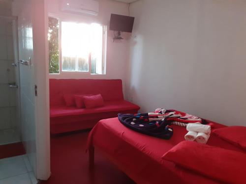 Habitación con cama roja y sofá rojo. en Magias da Serra, en Canela