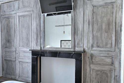a fireplace in a room with a wooden wall at Les Appartements Fénelon in Le Cateau