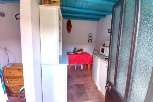 a kitchen with a table with a red table cloth at Casinha de Aldeia no coração da Costa Vicentina in Vila do Bispo