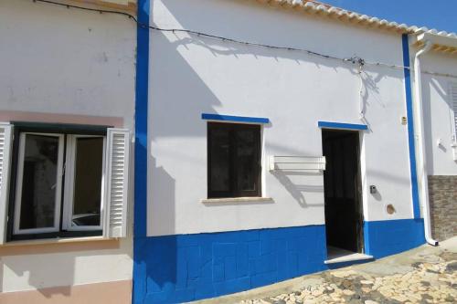 a blue and white house with two windows at Casinha de Aldeia no coração da Costa Vicentina in Vila do Bispo