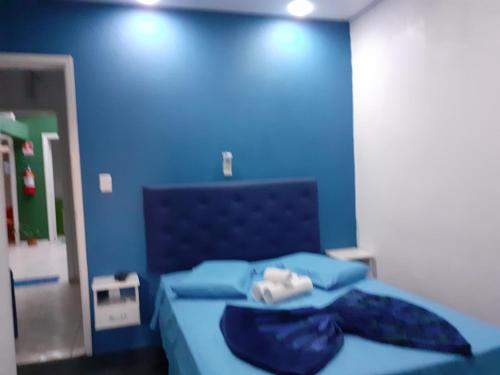 um quarto azul com uma cama com uma parede azul em Magias da Serra em Canela