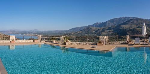 a large swimming pool with a view of the mountains at Villa Pomegrante in Exopoli