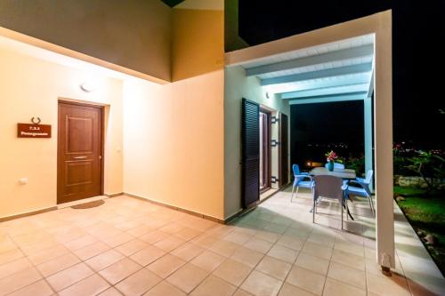 a patio with a table and chairs in a house at Villa Pomegrante in Exopoli