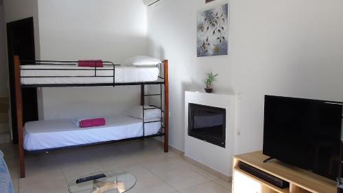 a room with two bunk beds and a flat screen tv at Villa Pomegrante in Exopoli