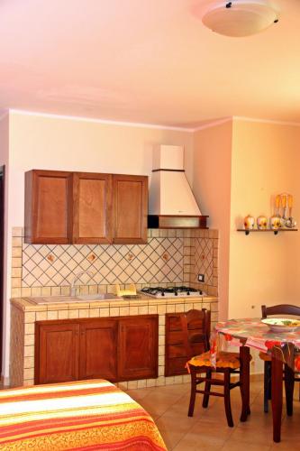 a kitchen with wooden cabinets and a stove top oven at Puesta De Sol Residence in Lampedusa